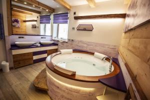 a bathroom with a large tub and two sinks at Chalet Tobià in Canazei