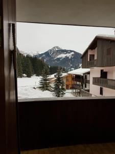 una ventana con vistas a una montaña nevada en Des Alpes 1, en Canazei