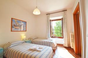 two beds in a room with a window at Agriturismo La Filanda in Manerba del Garda