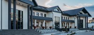 un edificio blanco con techos y escaleras negros en Restauracja Balton, en Grajewo