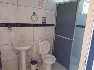 La salle de bains est pourvue de toilettes et d'un lavabo. dans l'établissement JOÃO CARLOS CASAS 3 Quartos #1, à Penha