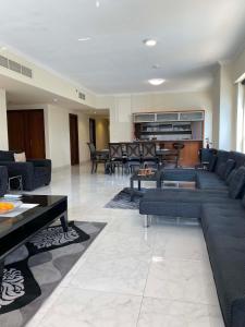 un soggiorno con divani, tavoli e sedie di My-Places Dubai Apartment suitable for large groups Al Sahab 1 a Dubai