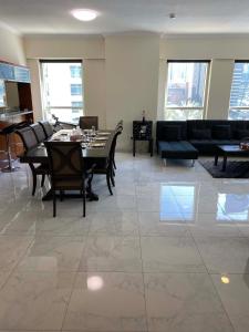 un soggiorno con tavolo, sedie e divano di My-Places Dubai Apartment suitable for large groups Al Sahab 1 a Dubai