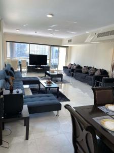 un soggiorno con divani blu e TV di My-Places Dubai Apartment suitable for large groups Al Sahab 1 a Dubai