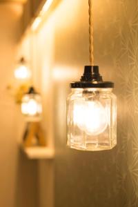 a glass jar hanging from a string with a light at Hôtel Le Chantilly in Deauville