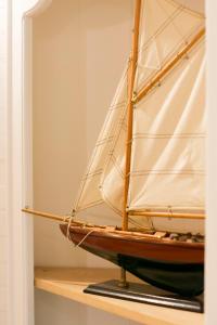 a model of a sail boat on a shelf at Hôtel Le Chantilly in Deauville