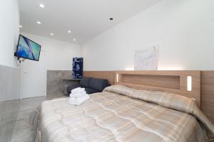 ein Schlafzimmer mit einem großen Bett und einem Flachbild-TV in der Unterkunft HG Boutique Toledo, Napoli Centro, by ClaPa Group in Neapel