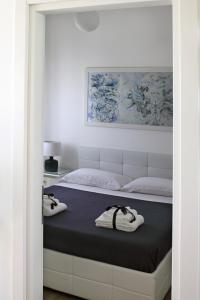 una camera da letto con un letto e due asciugamani di Dimora Grazia in Riva al Mare a Monopoli