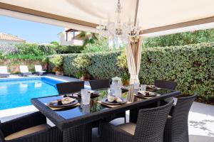 - une salle à manger avec une table et des chaises à côté de la piscine dans l'établissement Casa Lago, à Quinta do Lago
