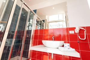 ein Bad mit einem Waschbecken und roten Fliesen in der Unterkunft HG Boutique Toledo, Napoli Centro, by ClaPa Group in Neapel