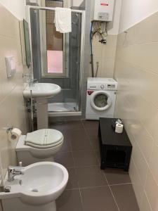 ein Badezimmer mit Toilette, Waschbecken und Waschmaschine in der Unterkunft Iris Inn in Salerno