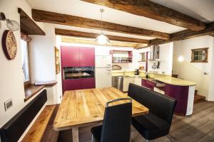 una cucina e una sala da pranzo con tavolo e sedie in legno di Chalet Tobià a Canazei