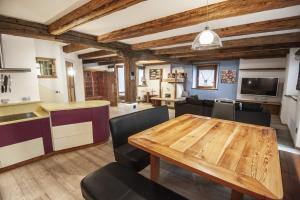 una cucina e un soggiorno con tavolo e sedie in legno di Chalet Tobià a Canazei