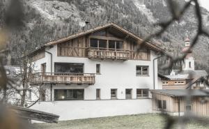 a large white building with a balcony and a church at Chalet Nr.121 in Pfunds
