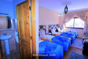 a bedroom with two beds and a sink in it at Gite Ghazal - Atlas Mountains Hotel in Imlil