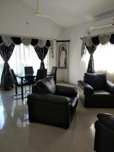 a living room with two couches and a table at Sai Maa Resort And Convention Centre in Puttaparthi