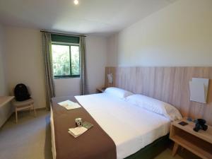 - une chambre avec un grand lit et une table dans l'établissement Albergue Monte Do Gozo, à Saint-Jacques-de-Compostelle