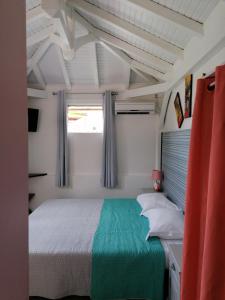 een slaapkamer met een bed en een raam bij Résidence B&L Lagon : Bungalow Corail in Sainte-Luce