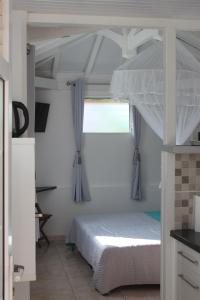 een slaapkamer met een stapelbed en een raam bij Résidence B&L Lagon : Bungalow Corail in Sainte-Luce