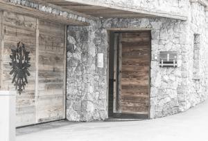 eine Tür zu einem Gebäude mit einer Steinmauer in der Unterkunft Chalet Nr.121 in Pfunds
