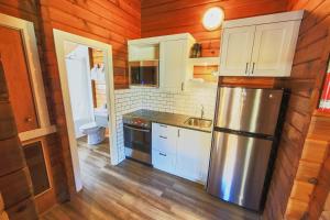 a kitchen with a stove, refrigerator, sink and cabinets at Jasper House Bungalows in Jasper