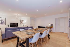 un soggiorno con tavolo e divano blu di Oxfordshire Living - The Churchill Apartment - Woodstock a Woodstock