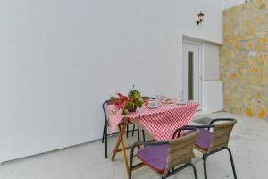 una mesa con sillas y un mantel rojo y blanco en Apartments Lavanda, en Turanj
