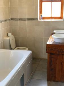 La salle de bains est pourvue d'une baignoire, de toilettes et d'un lavabo. dans l'établissement Caledon Country House, à Clarens