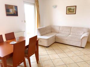 a living room with a white couch and a table at Vila Anica in Barbat na Rabu