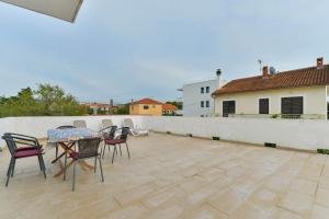 eine Terrasse mit Stühlen und einem Tisch auf dem Dach in der Unterkunft Apartments Lavanda in Turanj