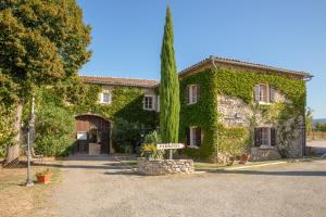 a ivycovered building with a sign in front of it at Auberge La Plaine in Chabrillan