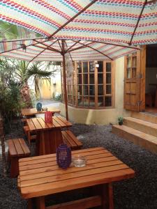 une terrasse avec des tables en bois et un parasol dans l'établissement Backpacker's Hostel Iquique, à Iquique