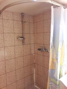 y baño con ducha y paredes de azulejos. en Bela apartment en Belá