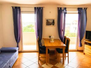 a dining room with a table and purple curtains at Vila Anica in Barbat na Rabu