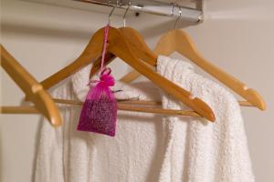 un estante de madera con toallas blancas y una bolsa rosa en City Center, en Tesalónica