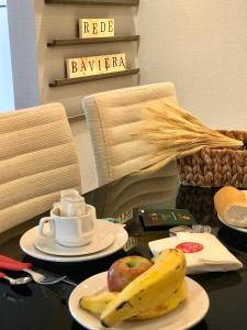 a table with a plate of fruit and a banana at Apartamento Vêneto in Canela