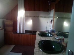 a bathroom with two sinks and a mirror at GUERINEL HERBERT PIERRETTE in Hirel