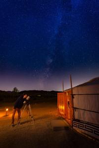 een man die een statief gebruikt om een foto te maken van de nachtelijke hemel bij 28 Palms Ranch in Twentynine Palms