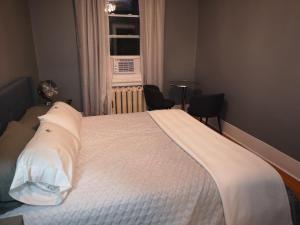 a bedroom with a bed with white sheets and a window at Room with King Bed in Shared 3 Bedroom Downtown in Montréal