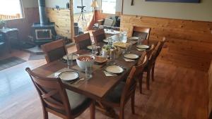a wooden table with chairs and a dining room with a fireplace at Caribou Lodge Alaska in Talkeetna