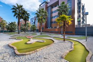 a golf course in front of a building with palm trees at Apartamento Fórum-Ciencias con Piscina, Gym & Parking in Granada
