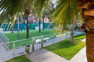 a park with a bench and palm trees and grass at Apartamento Fórum-Ciencias con Piscina, Gym & Parking in Granada