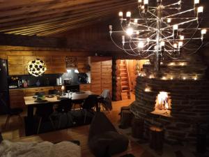 a dining room with a fireplace and a chandelier at Ruka Aava in Ruka