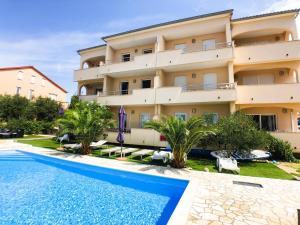 an apartment with a swimming pool in front of a building at Vila Anica in Barbat na Rabu