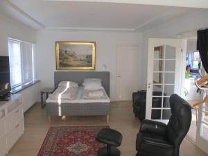 una camera con letto e sedia di Guesthouse Sharon Apartments a Arhus