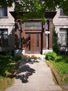 a house with a wooden door and a sidewalk at Room with King Bed in Shared 3 Bedroom Downtown in Montréal