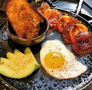 um prato de alimentos com ovos, carne e pimentos em Double Oaks Bed & Breakfast em Greensboro