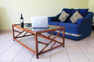 a coffee table with a bottle of wine and a laptop at Coral Vista Del Mar in Ixtapa