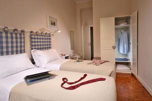 una habitación de hotel con 2 camas con una cinta roja. en Residenza I Rioni Guesthouse, en Roma
