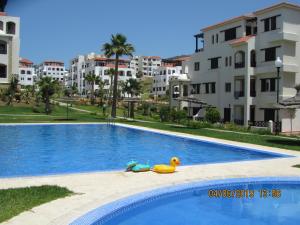 a swimming pool with a rubber duck and some buildings at Bel appartement 3chambres Lilac's Garden Cabo Negro in Cabo Negro